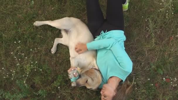 Jong meisje is wandelen met de hond in het bos — Stockvideo