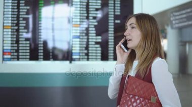Akıllı fark ile bulanık çetele arka plan üzerinde genç kadın konuşuyor