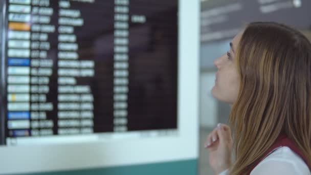 Smukke pige står og valg flyvning på baggrund af sløret resultattavle med meddelelsen – Stock-video