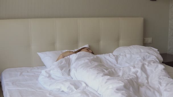 Young woman wakes up in bed — Stock Video