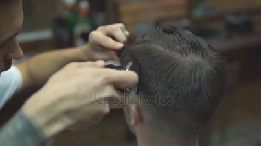 Ana kesim saç ve sakal Berber Dükkanı'nın adamlarından, Kuaför saç modeli için genç bir adam yapar.