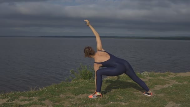 Mujer en ropa deportiva azul, práctica de yogui al aire libre . — Vídeos de Stock