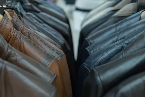 Chaquetas de cuero negro y marrón en rack, primer plano — Foto de Stock