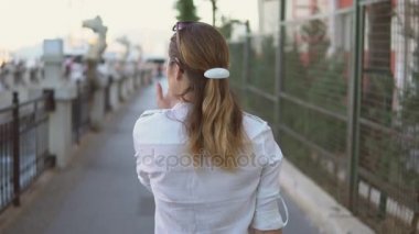 genç güzel kız güzel şehir manzaraları arka plan üzerinde yürüyüş.