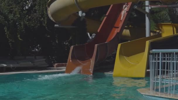 Mulher desliza para baixo da corrediça na piscina — Vídeo de Stock
