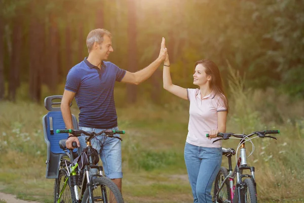 Happy couple with bikes funs in pine forest