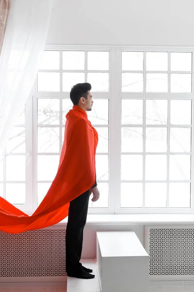 Hombre de negocios con capa de superhéroe rojo. Joven con traje y capa de superman en las escaleras — Foto de Stock