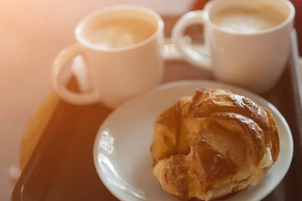 Two cups of cappuccino and croissant cup on the table, selective focus. — Stock Photo, Image