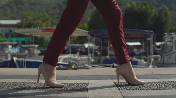 Красивые ноги деловой женщины в обуви идут на пирс на фоне красивой природы . — стоковое фото