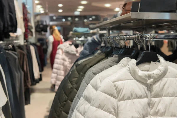 Chaquetas de plumón blancas, negras y grises en el rack, tienda — Foto de Stock