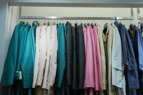 Řádek z podzimních kabátů zavěšených na stojanu, nákupní — Stock fotografie