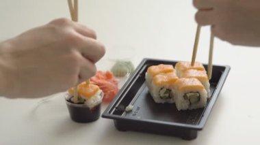 El ile chopsticks ve suşi rulo konteyner teslim alır.