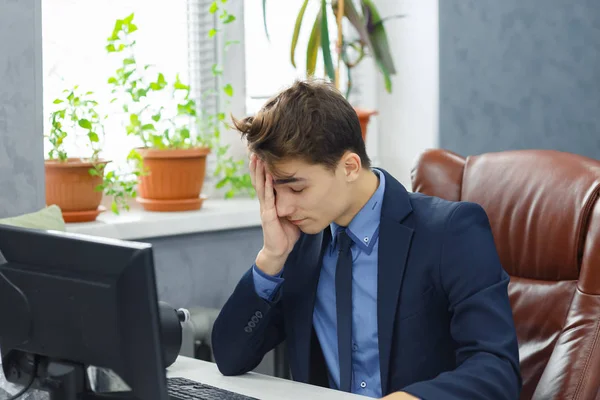 Cansado triste deprimido hombre de negocios en traje formal trabajando en la computadora en la oficina . — Foto de Stock