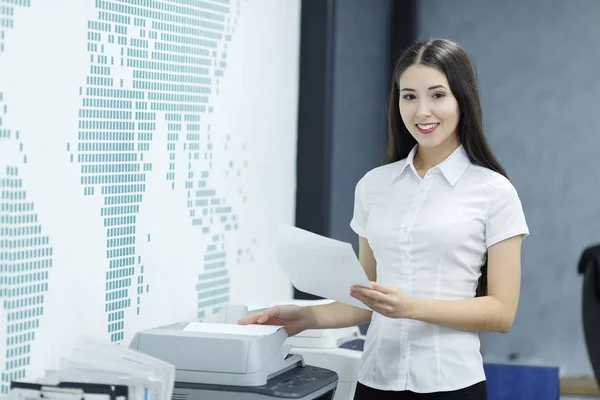 Wanita pengusaha muda yang cantik menggunakan printer di meja kantor modern — Stok Foto