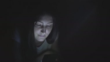 Güzel kız yatakta o gece uyku önce tablet kullanma.