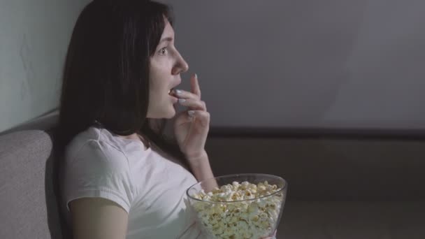 Genç kız yalnız bir korku filmi izlerken. — Stok video