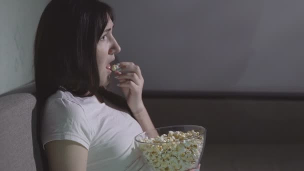 Ung vacker flicka ensam är att titta på en skräckfilm — Stockvideo