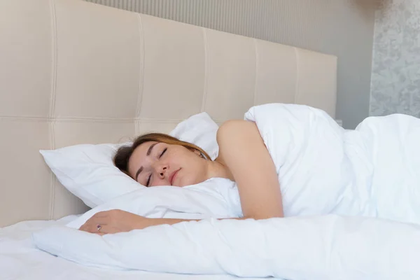 Menina bonita acorda em cama grande no hotel — Fotografia de Stock