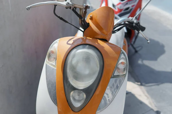 Motocicleta em branco e laranja à tarde no estacionamento — Fotografia de Stock