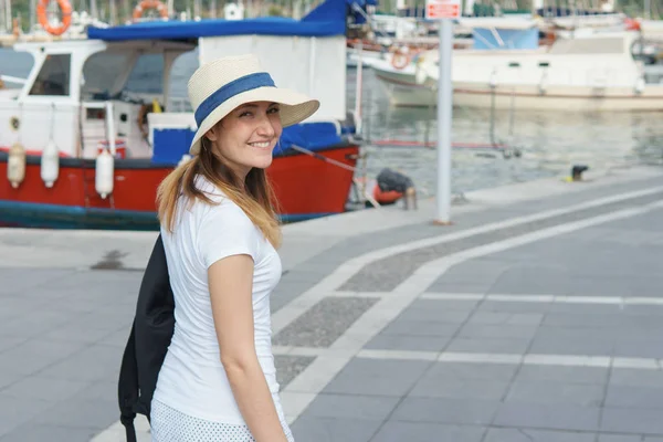 Молодая женщина на прогулке вдоль набережной к пирсу в солнечный день . — стоковое фото