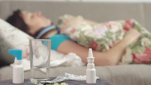 दवाएं बेडसाइड टेबल पर पड़ी हैं और बिस्तर में बीमार लड़की की धुंधली . — स्टॉक वीडियो