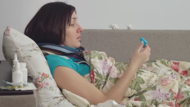 Mujer enferma acostada en la cama en casa, dolor de garganta — Vídeos de Stock