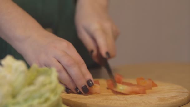Slijpen van groenten voor de salade op een houten snijplank — Stockvideo