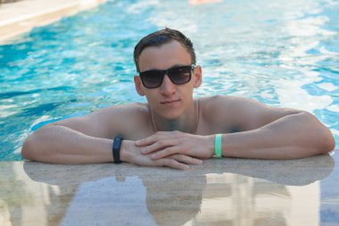 Adam bir açık havuzda yüzme güneş gözlüğü