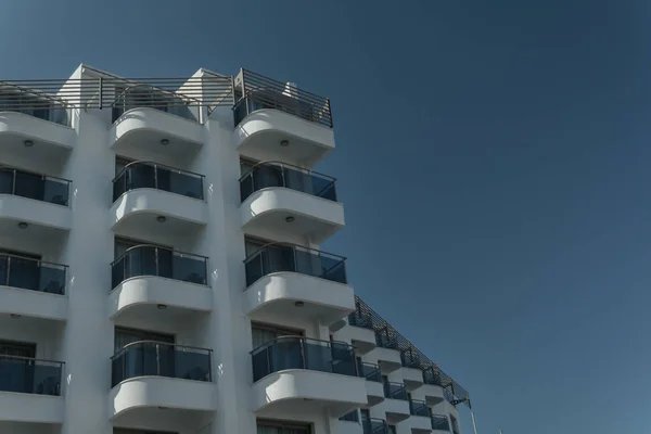 Edifício alto com varandas contra um fundo de céu claro — Fotografia de Stock