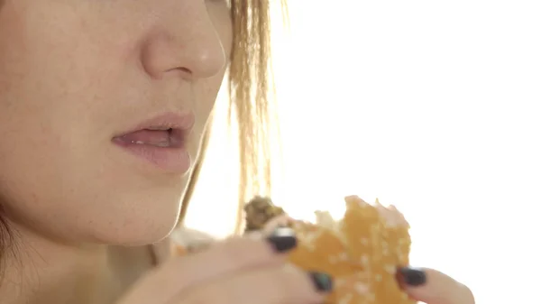 Jovem mulher comer hambúrguer apetitoso — Fotografia de Stock