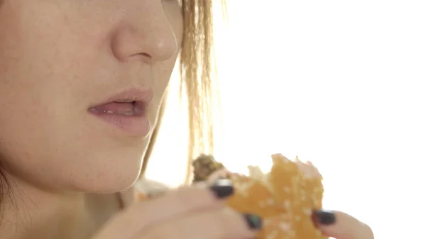 Young woman eating appetizing burger — Stock Photo, Image