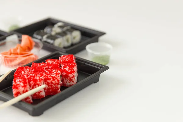 Sushi rolletjes met zalm en gember op een witte houten tafel — Stockfoto