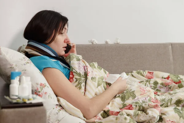 Mujer enferma acostada en la cama en casa hablando por teléfono — Foto de Stock