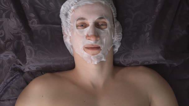 Junger Mann im Schönheitssalon mit Gesichtsmaske — Stockvideo