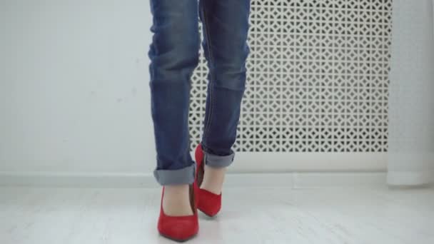 Little girl in mothers red shoes walks around the house — Stock Video