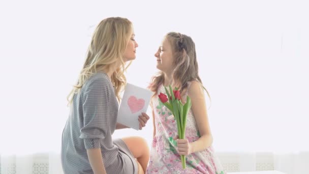 Daughter gave her mother a bouquet of tulips and a postcard made by own hands — Stock Video