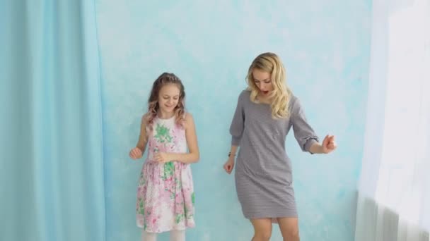 Matka a dcera tančí u okna. Zábava a radost — Stock video
