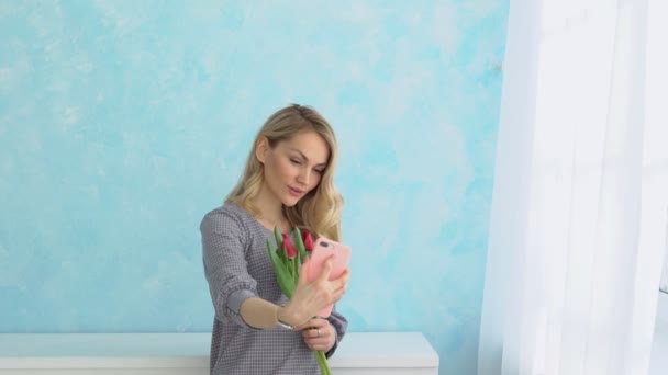 Mooi meisje met een boeket van tulpen selfie maken op de telefoon. — Stockvideo