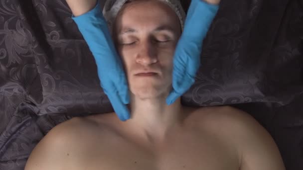 Knappe man met gezicht massage in de spa salon — Stockvideo