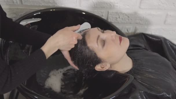 Ung flicka i skönhetssalong. Tvätta huvudet — Stockvideo