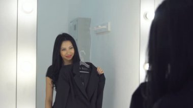 Güzel genç kadın bir elbise bir ayna yakınındaki sonra görünüyor