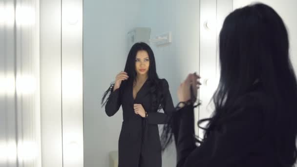 Mooi meisje meten van een jurk in de buurt van een spiegel. — Stockvideo