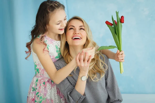 Счастливого Дня Матери. Ребенок дочь поздравляет мам и дает ей открытку и цветы тюльпаны . — стоковое фото