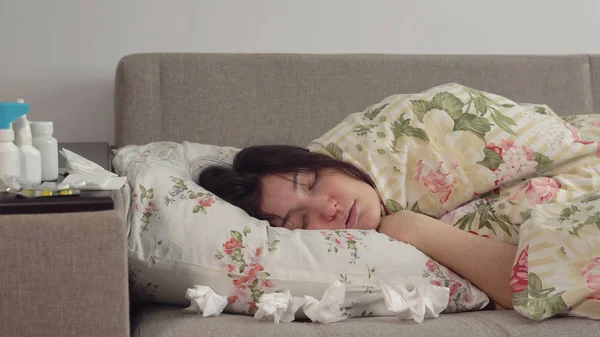 Giovane donna sdraiata sul letto avvolta in una coperta — Foto Stock