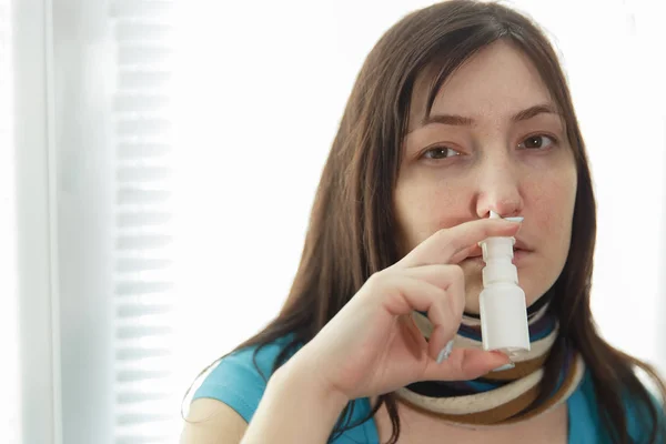 Mujer joven enferma y un spray nasal —  Fotos de Stock