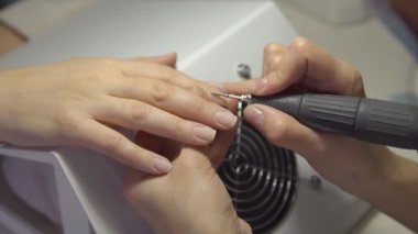 Tırnak-master Güzellik Salonu manikür için genç bir kadın yapar. Temizleme ve parlatma