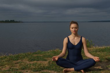 Mavi spor giyim açık meditasyon içinde genç kız