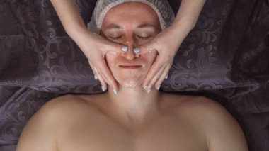 Spa merkezinde yüz masajı alma yakışıklı bir genç adam, yakın çekim