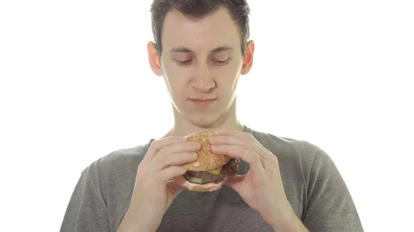 Jovem come um hambúrguer, comida não saudável — Fotografia de Stock