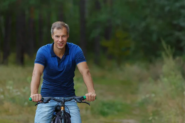 Человек ездит на велосипеде в сосновом лесу, спортивный отдых — стоковое фото